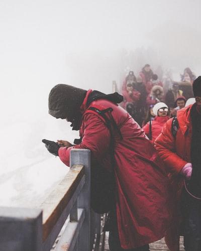 人们穿红色外套走在桥
